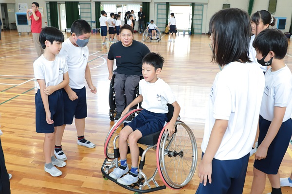 写真：児童らが競技用車いすを体験する様子
