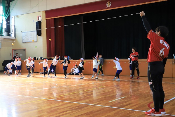 写真：選手の指導でボールを投げる児童たち